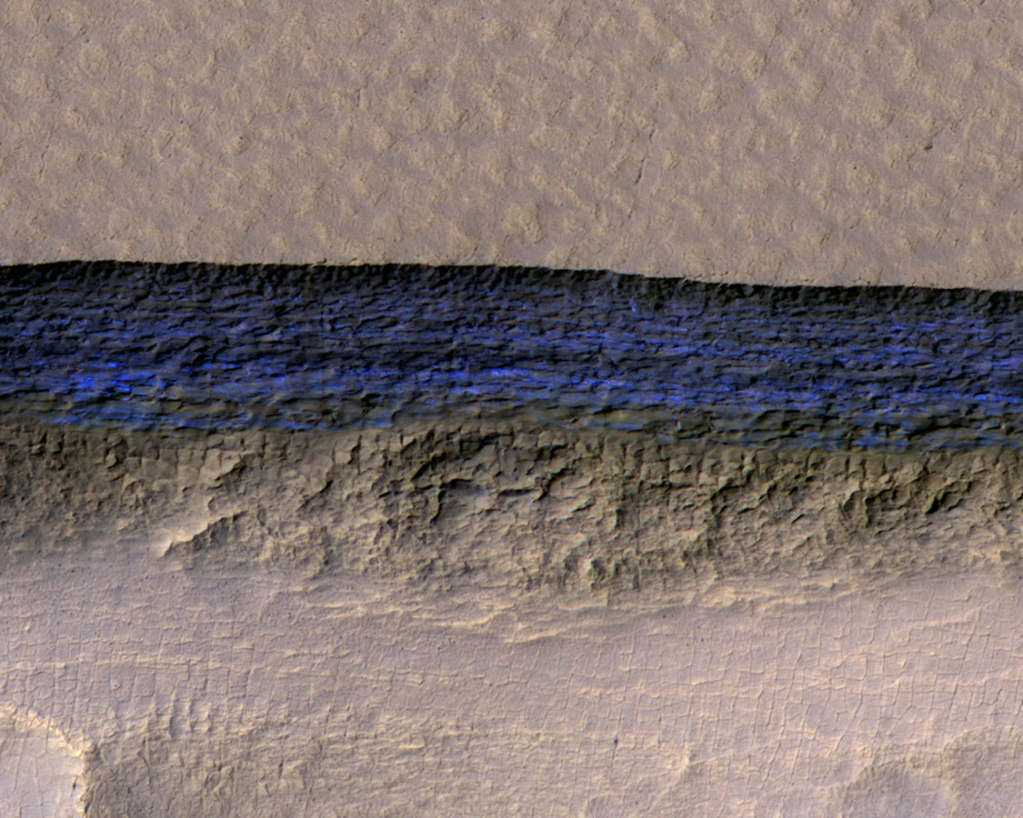 A cross-section of a thick sheet of underground ice is exposed at the steep slope (or scarp) that appears bright blue in this enhanced-color view from the High Resolution Imaging Science Experiment (HiRISE) camera on NASA’s Mars Reconnaissance Orbiter