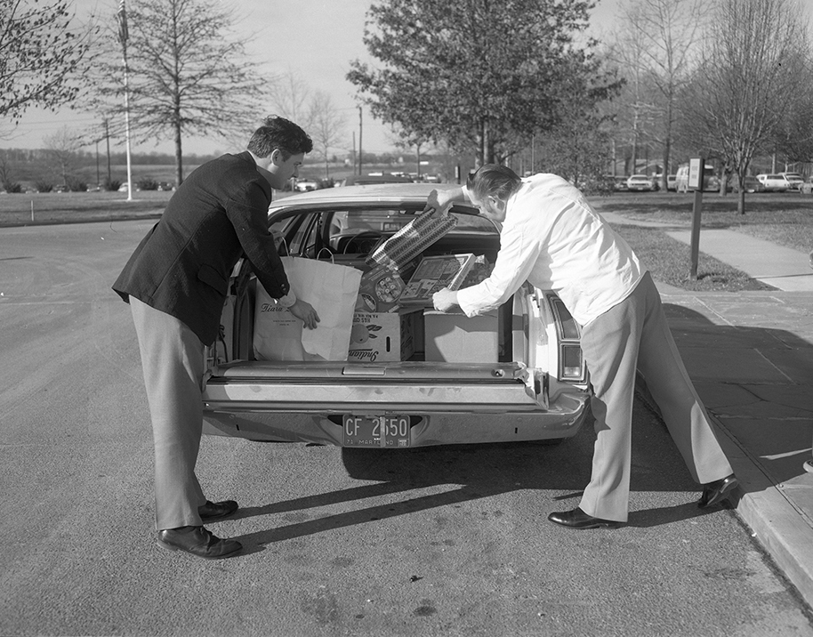 APL staff members load gifts for sick children into a station wagon (1975)