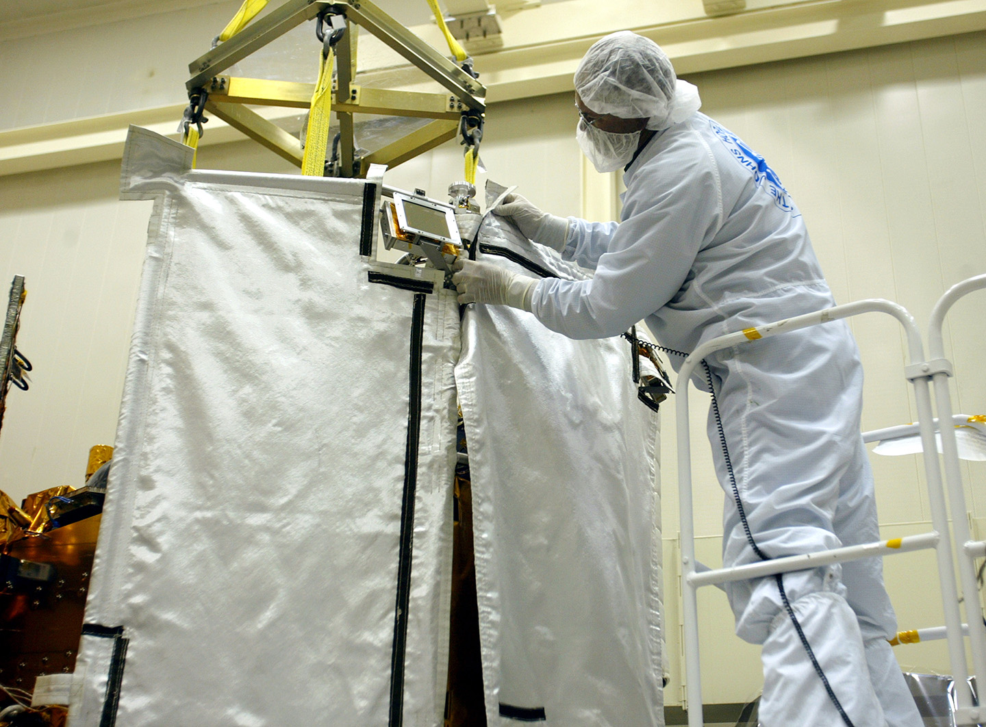 Neal Bachtell of The Johns Hopkins University Applied Physics Laboratory (APL), Laurel, Md., attaches the middle section of the ceramic-fabric sunshade to the Mercury-bound MESSENGER spacecraft.
