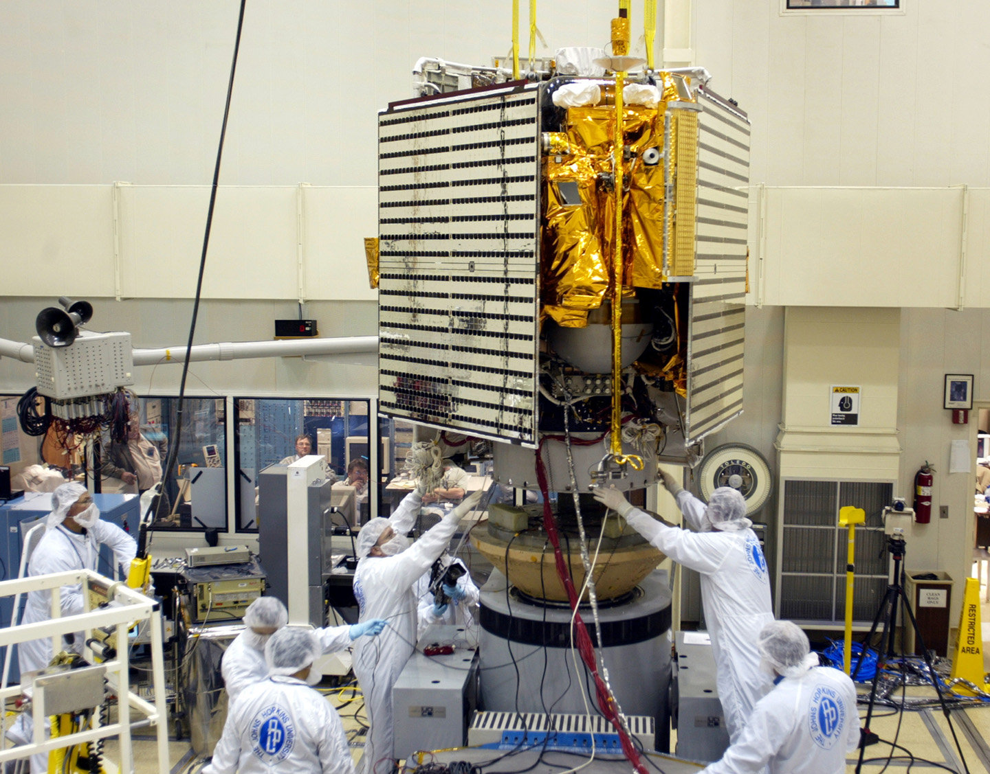 MESSENGER team members adjust the Mercury-bound spacecraft’s ceramic-fabric sunshade before conducting vibration tests