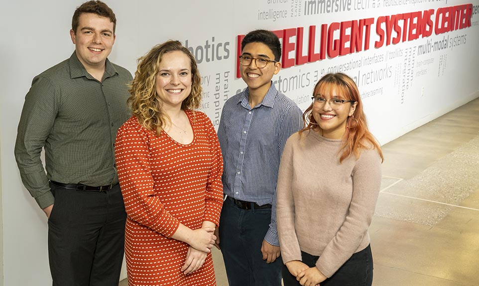 Four people smiling and posing together