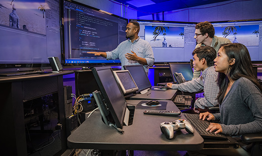 Four people working with the ARENA screens