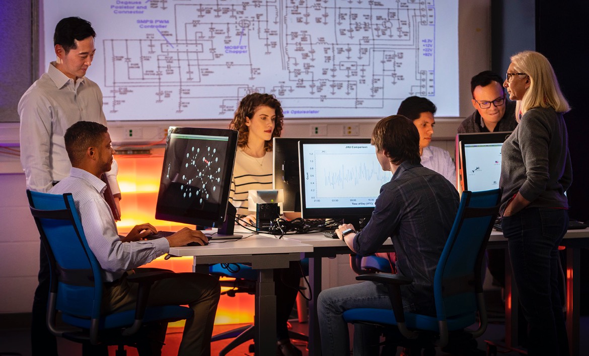 A group of APL staff members work together in a computer lab