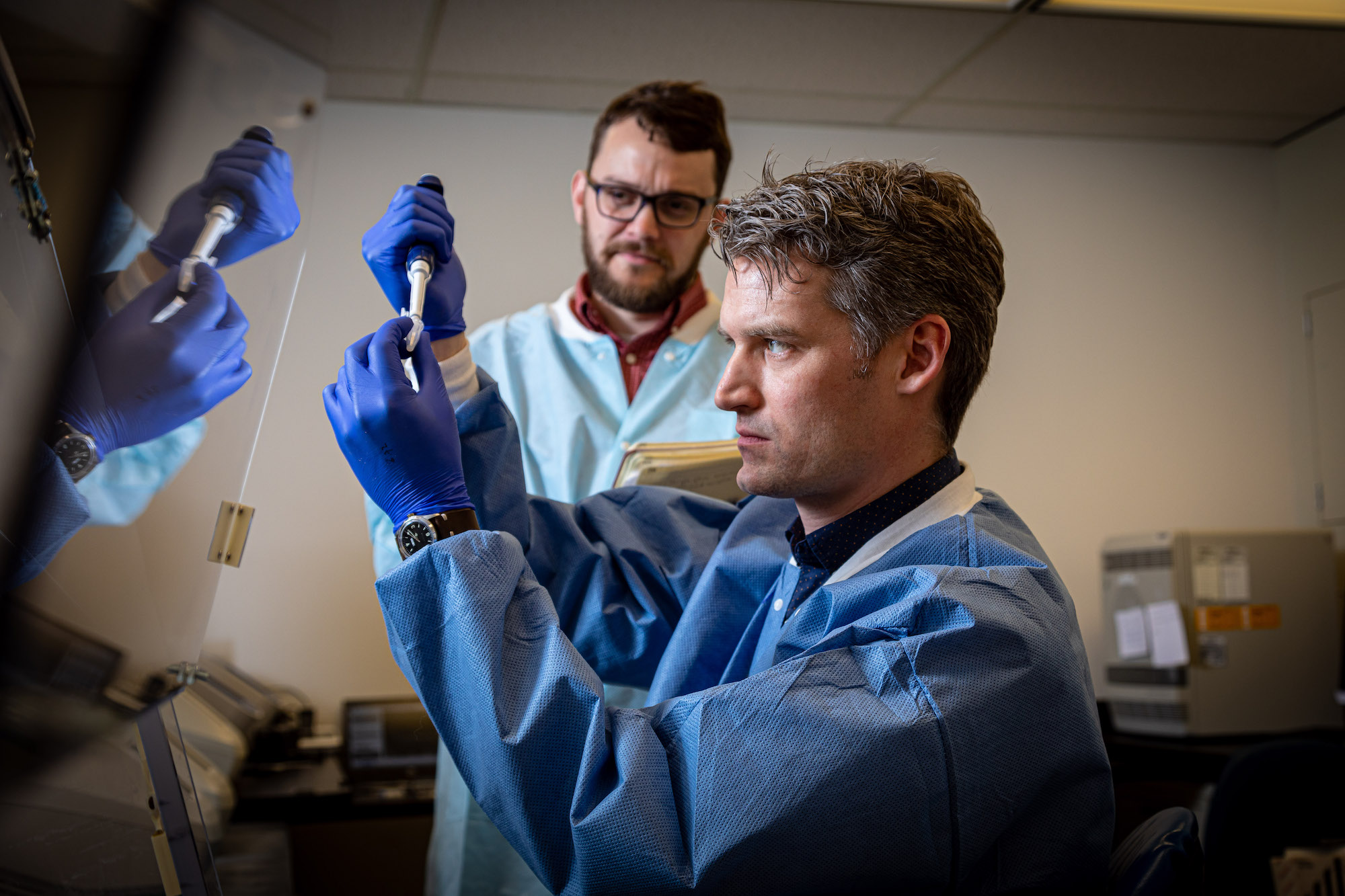 Peter Thielen, front, works with Tom Mehoke on immediate sequencing of the SARS-CoV-2 genome, the virus that causes COVID-19, at the Johns Hopkins Hospital molecular diagnostics laboratory.