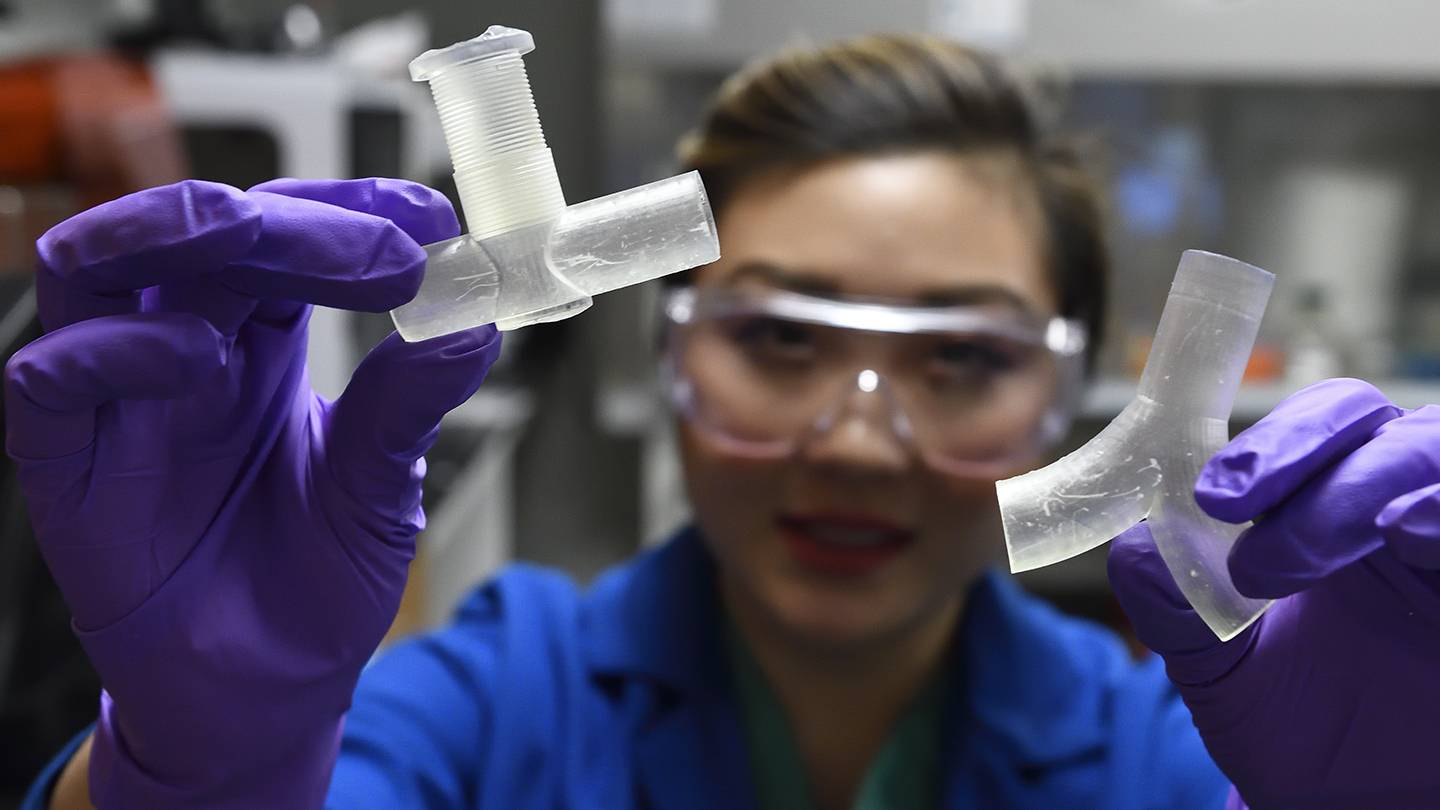 Helen Xun, a third-year medical student at the Johns Hopkins School of Medicine, holds up a 3D-printed ventilator splitter.