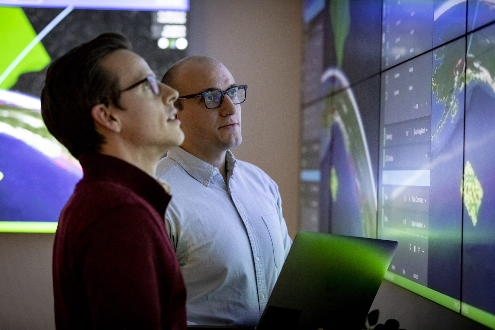Cerberus Project Manager Travis Heslop, center, and Derrick Treichler, a Cerberus technical lead, review designs and updates for the latest prototype. APL’s Cerberus project team laid out a three-year plan to design, build, field and iterate an advanced prototype. APL demonstrated an initial working version in just twelve months. Credit: Johns Hopkins APL