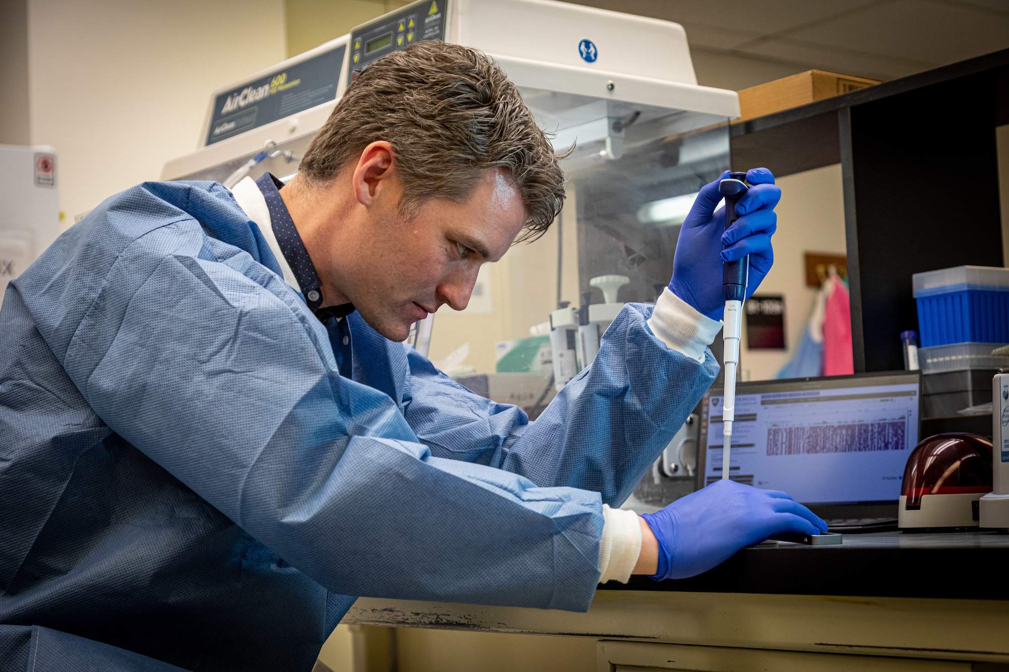 Johns Hopkins APL molecular biologist Peter Thielen prepares a handheld DNA sequencer for operation at the molecular diagnostics laboratory at Johns Hopkins Hospital in late March.