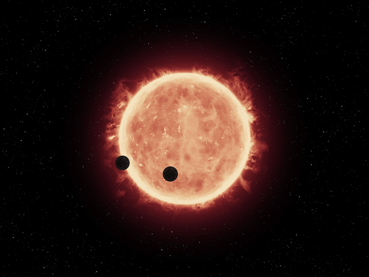 Artist’s illustration of two Earth-sized planets passing in front of their parent red dwarf star.