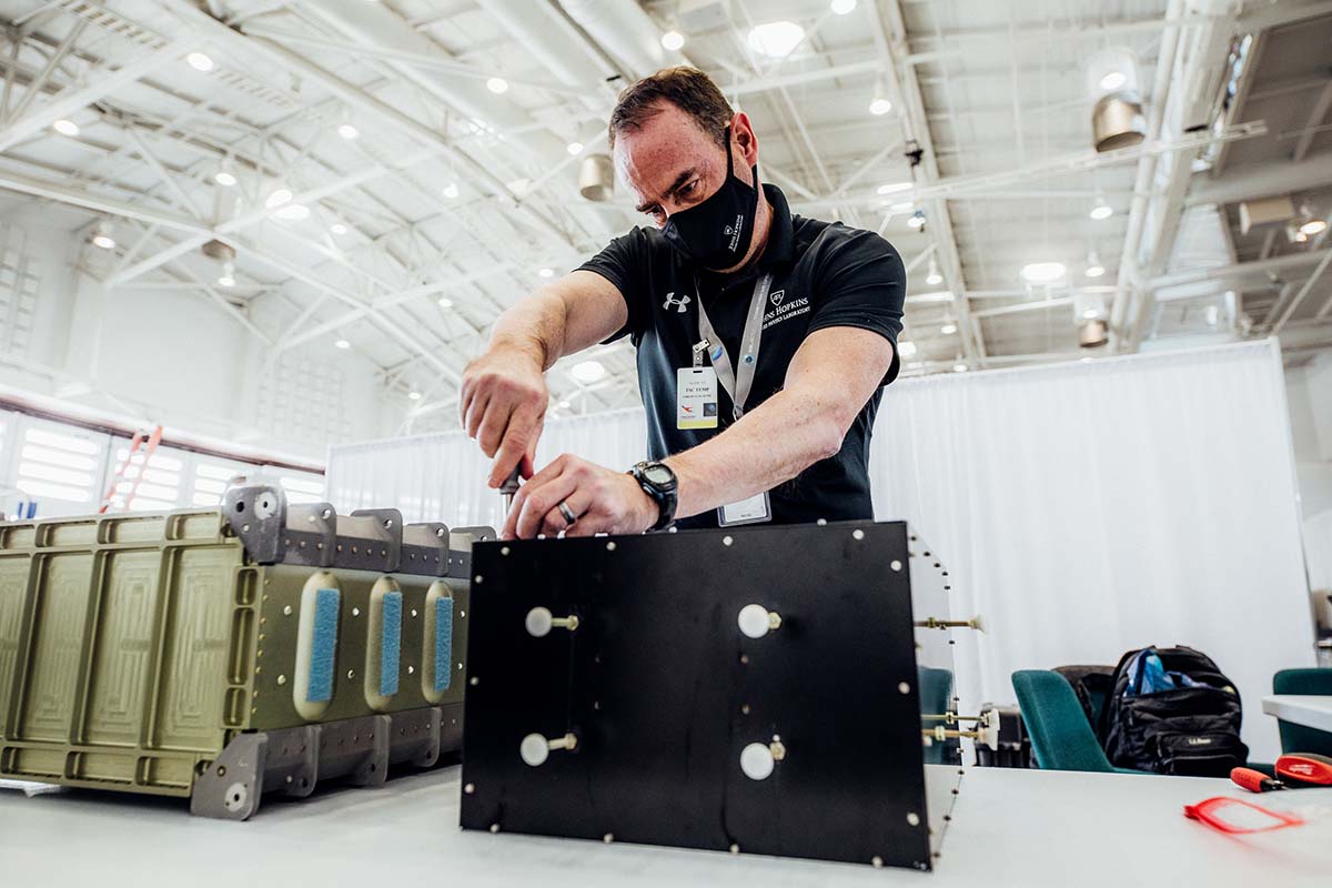 Todd Smith, of the Johns Hopkins Applied Physics Laboratory, prepares the JHU APL Integrated Universal Suborbital (JANUS) platform for a Virgin Galactic test flight