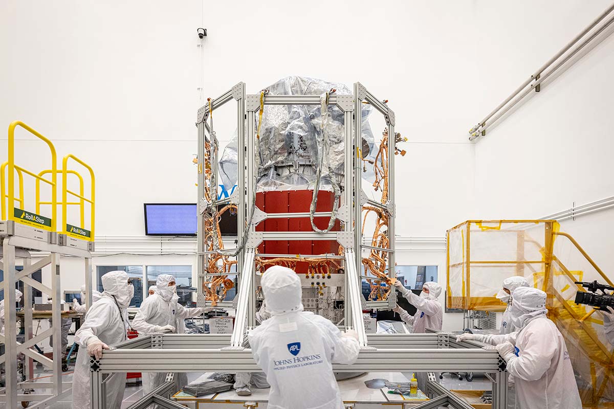 In a clean room at the Johns Hopkins Applied Physics Laboratory in Laurel, Maryland, Europa Clipper's propulsion module harness, installed onto a bake-out fixture, is rolled up to the propulsion module in preparation for transfer and installation.