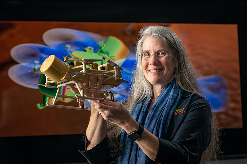 Elizabeth “Zibi” Turtle, recipient of the Division for Planetary Science’s Claudia J. Alexander Prize, holds a scale model of the Dragonfly spacecraft. Credit: Johns Hopkins APL/Ed Whitman