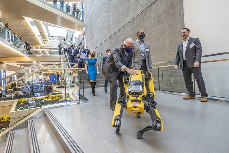 Maryland Gov. Larry Hogan interacts with Spot the robot dog before a presentation on APL’s work in artificial intelligence