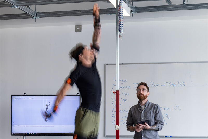 Lindsey observes a pilot test of a maximum vertical jump. Participants’ maximum vertical jump is tested throughout the exercise protocol as one method of monitoring their fatigue level.