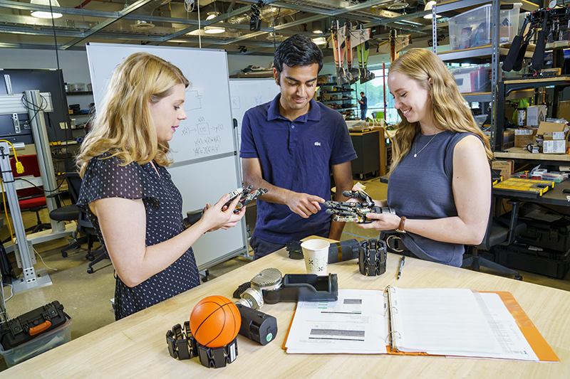 Three students working with robotics