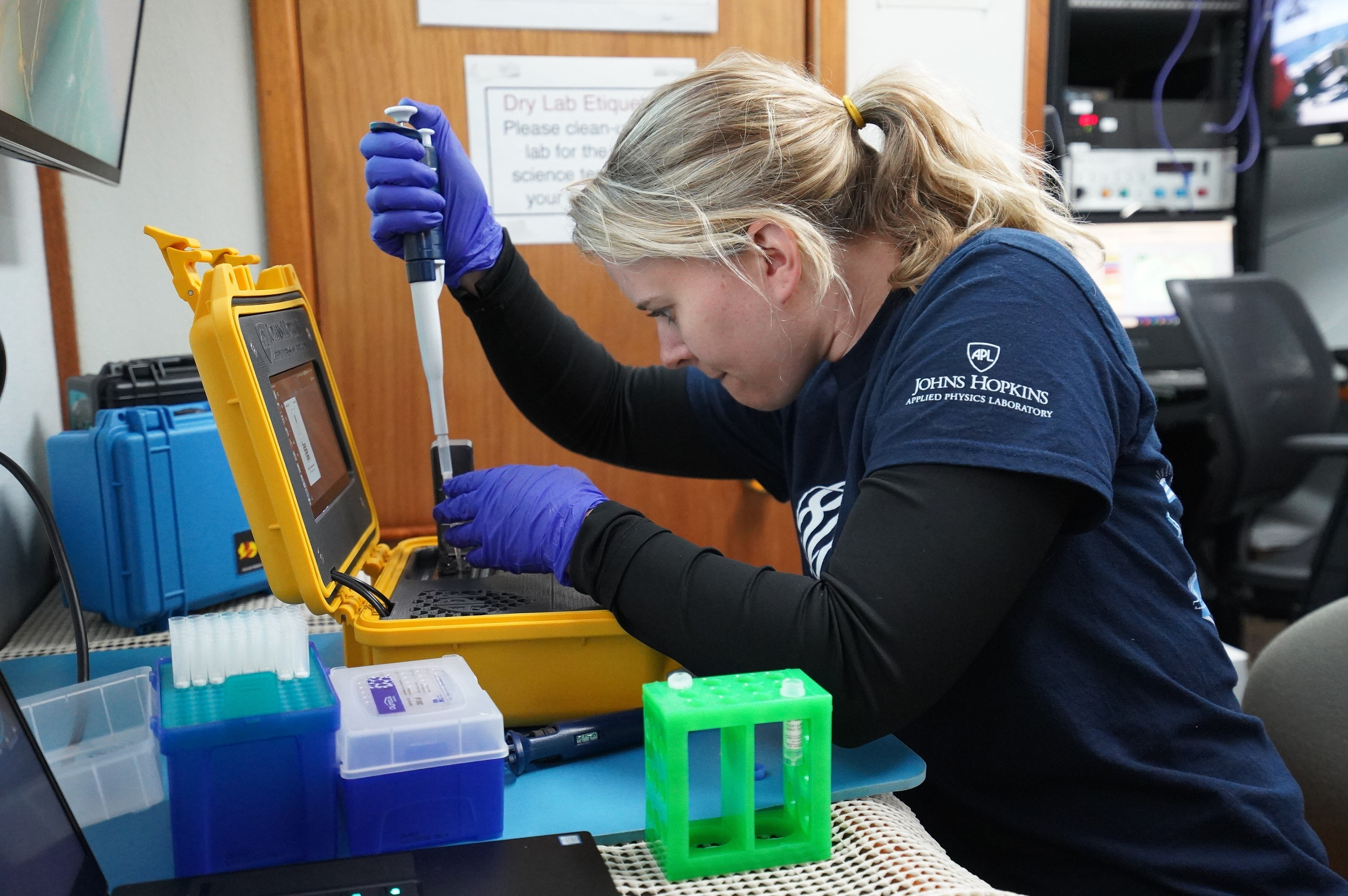 Hayley DeHart, a genomics research scientist at APL, loads water samples into a sequencer
