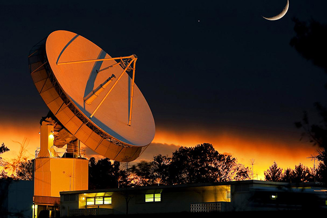 Johns Hopkins APL's 60-foot dish antenna illuminated at night