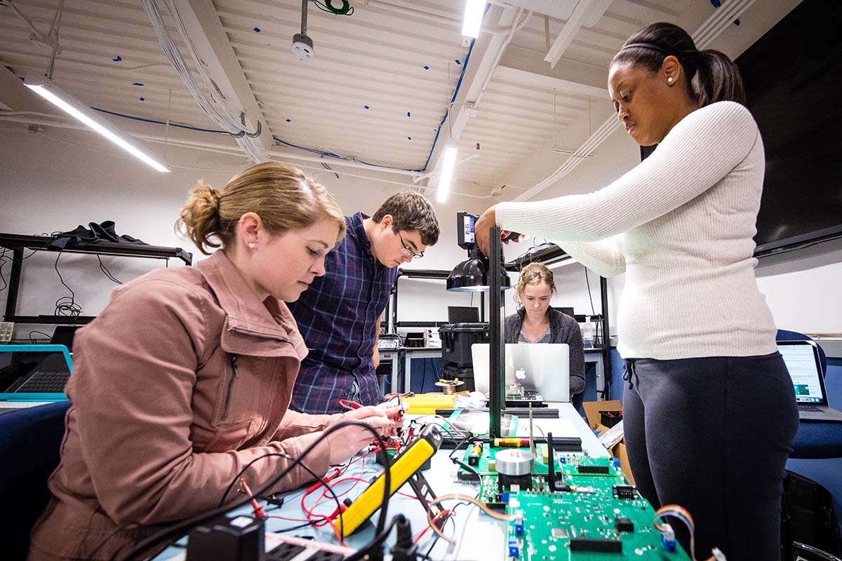 Four Johns Hopkins Engineering for Professionals students collaborate on a hands-on classroom activity