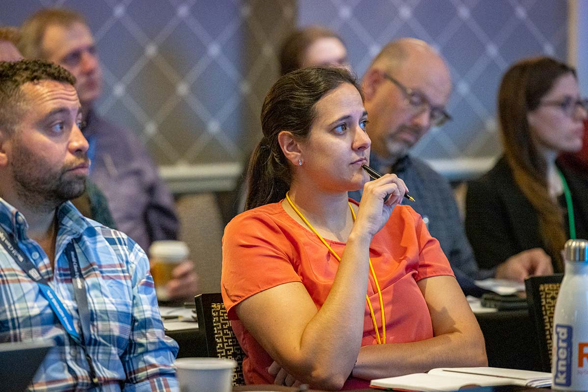 A conference attendee listens to a presentation