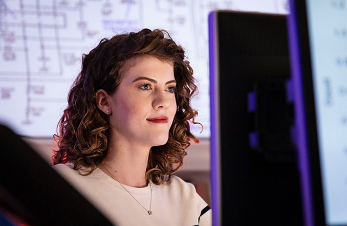 An APL staff member smiling as she works at a computer