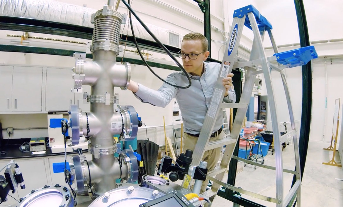 An APL staff member adjusting a piece of equipment in a lab