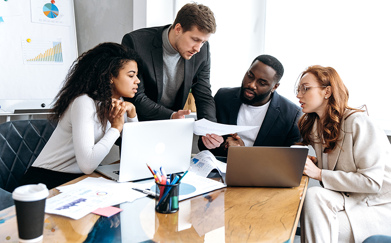 Four people discussing work at a table