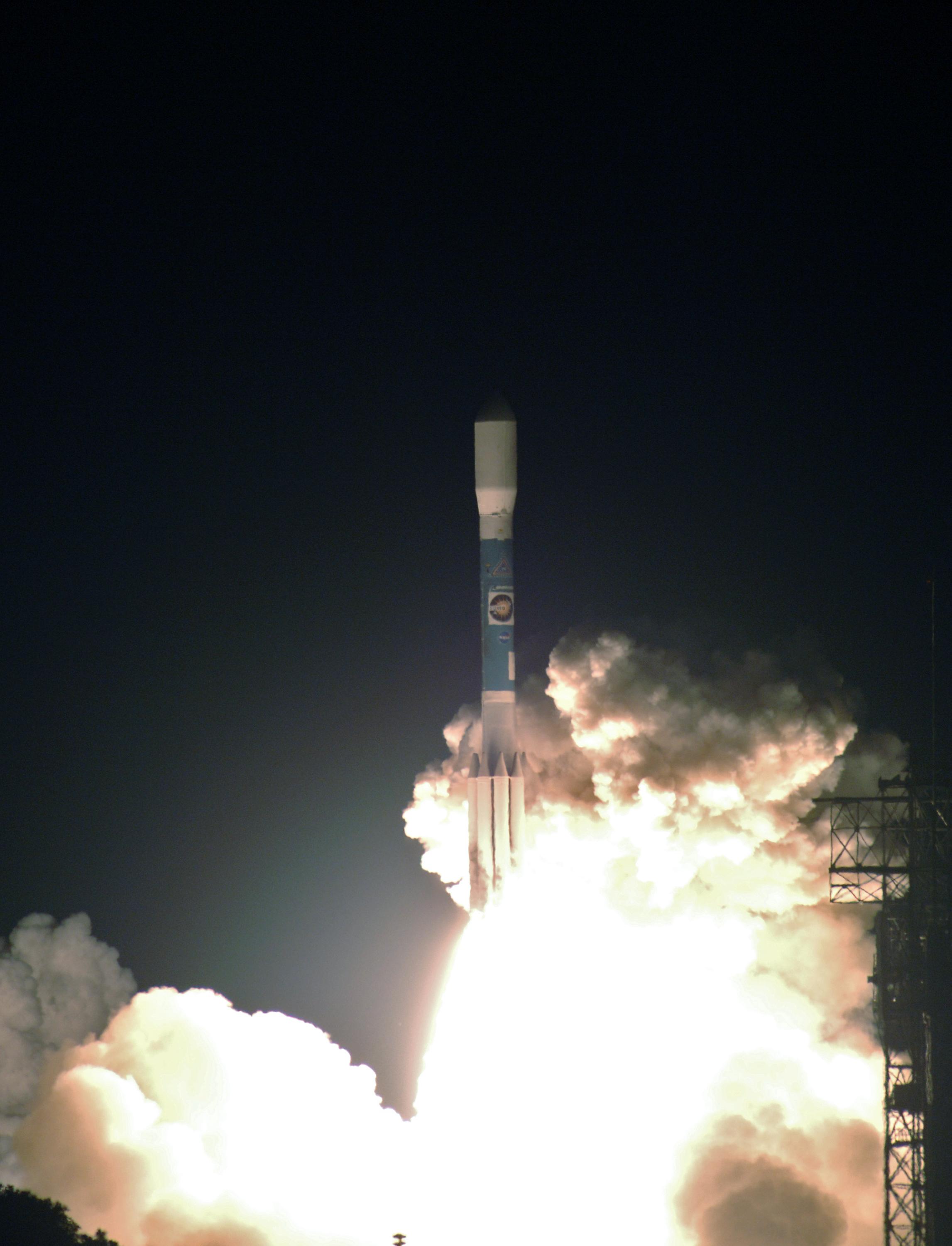 The Delta II launch vehicle carrying the STEREO spacecraft hurtles through the smoke and steam after liftoff from Launch Pad 17-B at Cape Canaveral Air Force Station