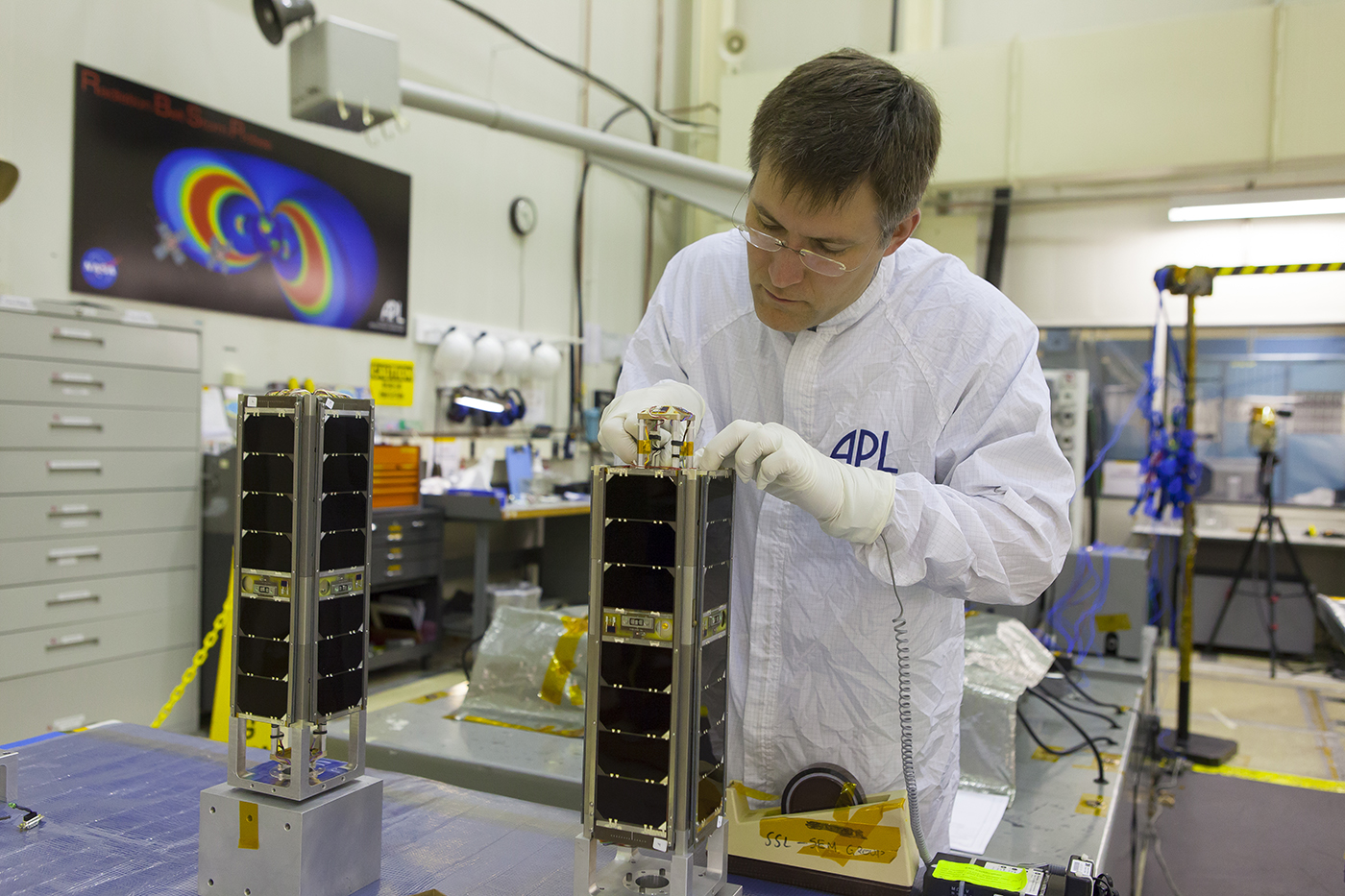 A Johns Hopkins Applied Physics Laboratory technician prepares the twin Multimission Bus Demonstration satellites