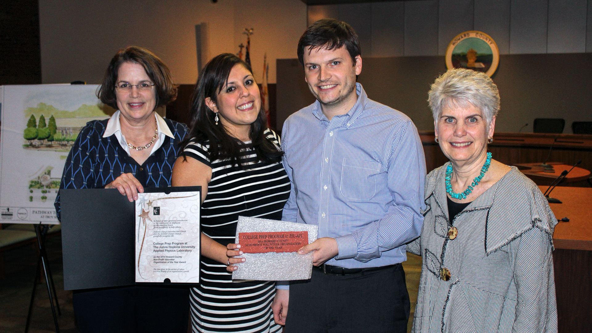 Howard County Council members Courtney Watson (far left) and Mary Kay Sigaty (far right) congratulate Karla and Will Gray Roncal, founders of the College Prep Program at APL