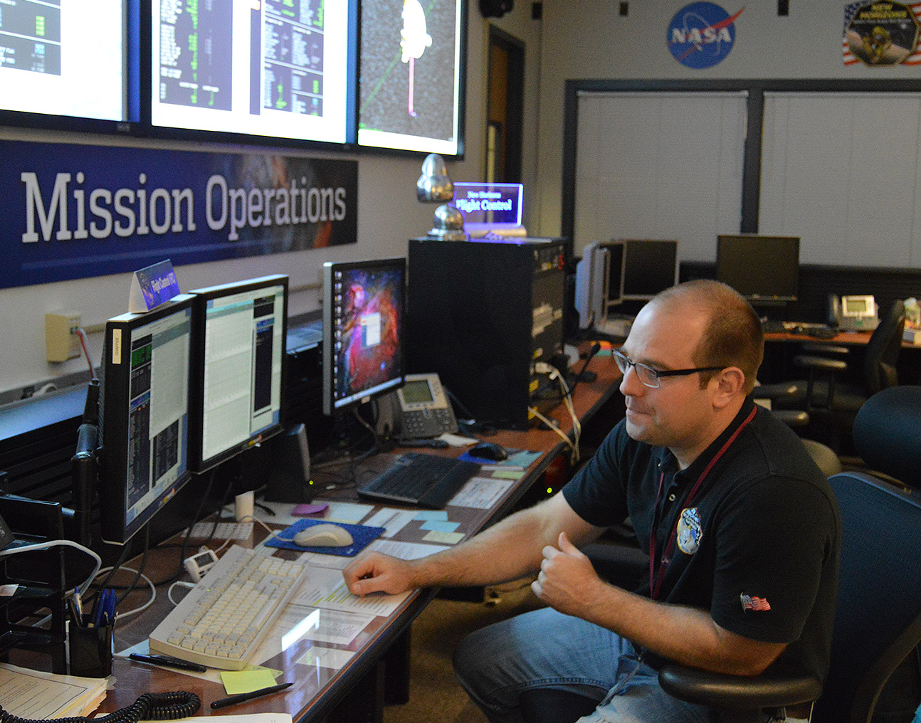 Flight controller George Lawrence monitors spacecraft data as it streams into the New Horizons Mission Operations Center