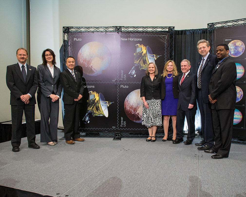 Representatives from NASA and the New Horizons mission team unveil the “Pluto — Explored!” set of U.S. postage stamps