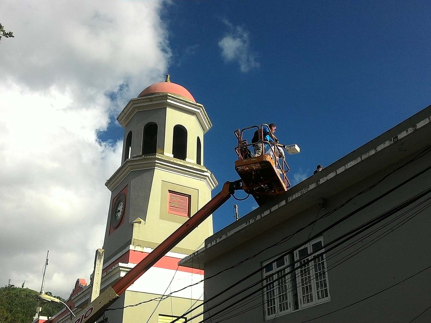 Merheb and his father move equipment onto the roof of a building for installation