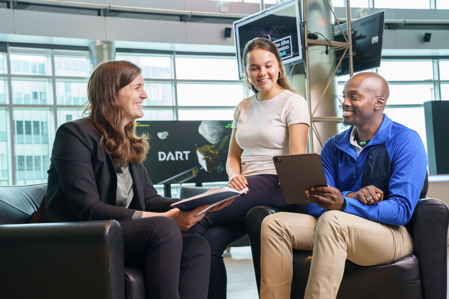 Three APL staff members converse in a building lobby