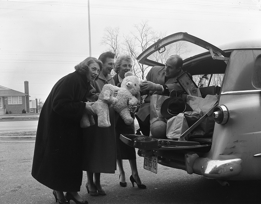 Carolyn Oberlin, Ruth Moore, Vera Wolchick, and Bill Groff load a station wagon with donated toys (1955)