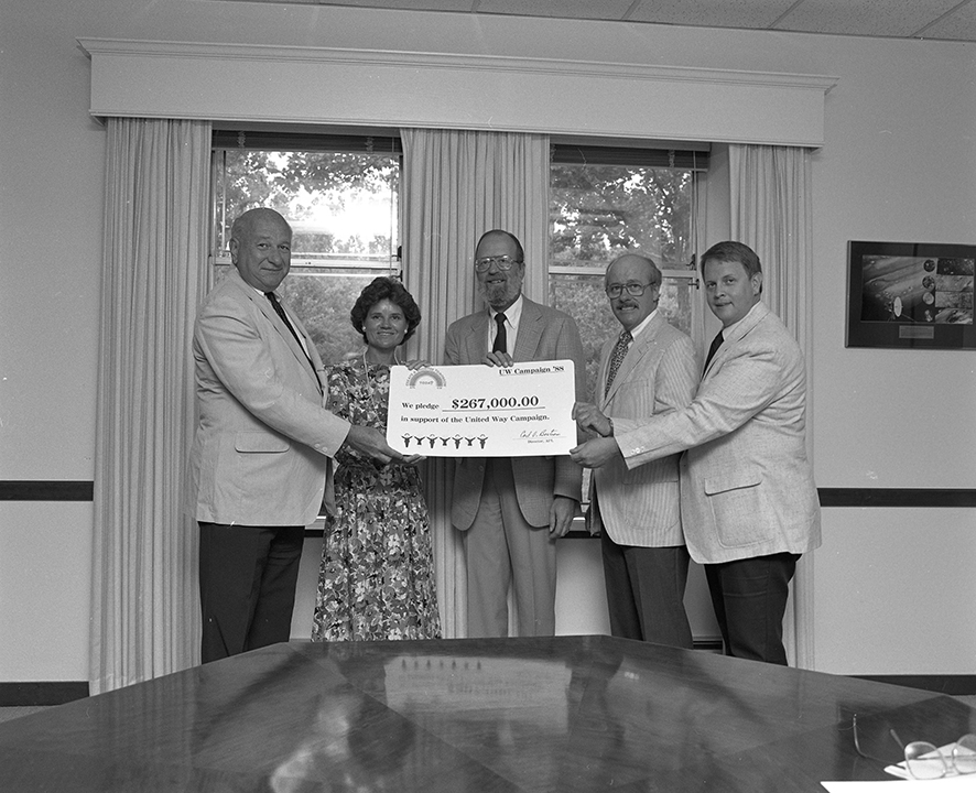 Carl Bostrom is shown here holding a certificate of an APL pledge for the United Way