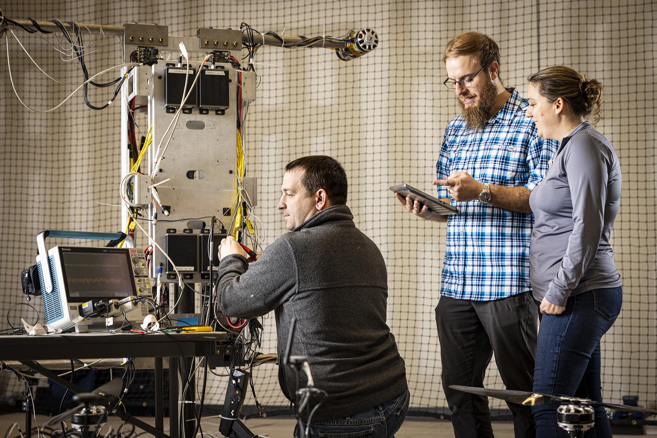 Engineers (from left) John Samsock, Anthony Drewicz and Stephanie Lepchenske work with a test platform in the Dragonfly Flight Lab