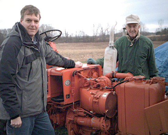 Ron Buikema, left, with a tractor that made its way to Haiti before the disaster