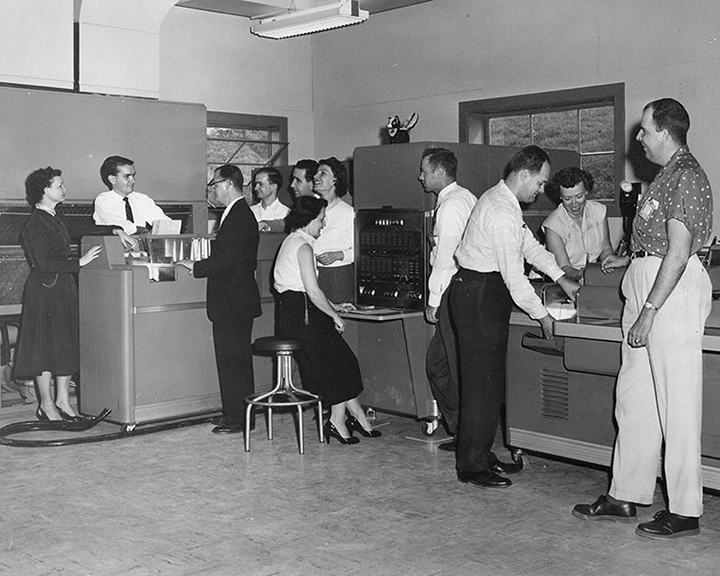 Robert Rich (center left, in suit), head of the Bumblebee Computing Center, inspects the new Remington Rand UNIVAC computer with his colleagues