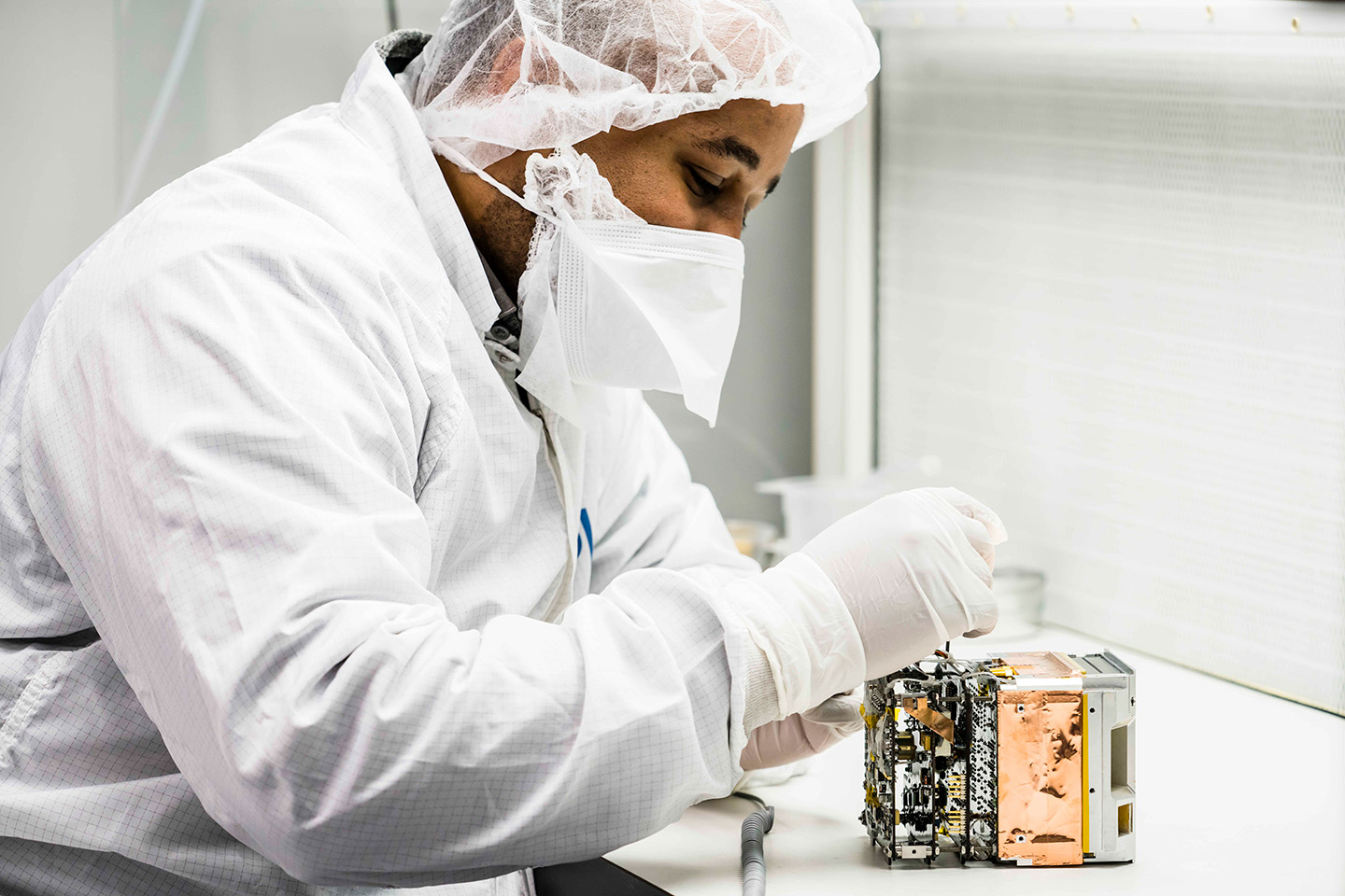 APL computer engineer Clifton Lomax inspects the Relativistic Electron Atmospheric Loss (REAL) instrument.