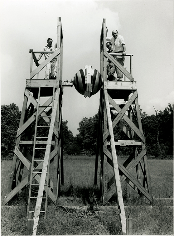 ilfred Zimmerman (left), David Moss, and James Smola test a mechanism designed to prevent the Transit 1A satellite from spinning while in orbit. (1958)
