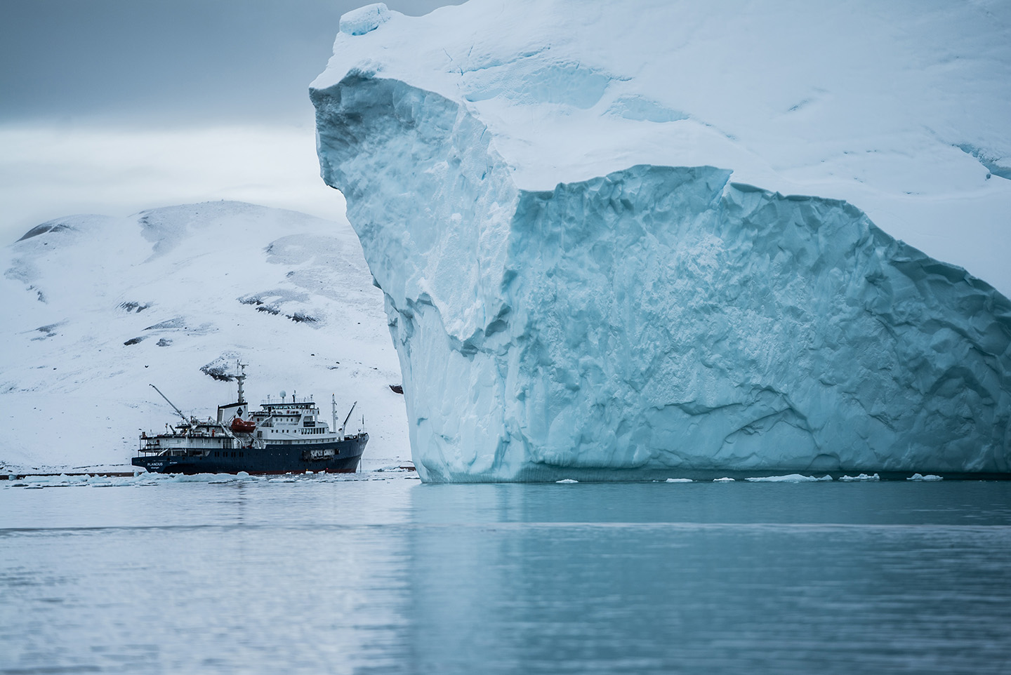 A vessel passes by icebergs near Greenland (Credit: Hubert Neufeld)