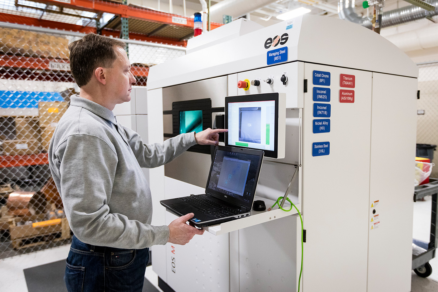 Additive Manufacturing Engineer John Slotwinski checks the progress of complex metal parts being fabricated inside APL's metal powder bed fusion additive manufacturing system.
