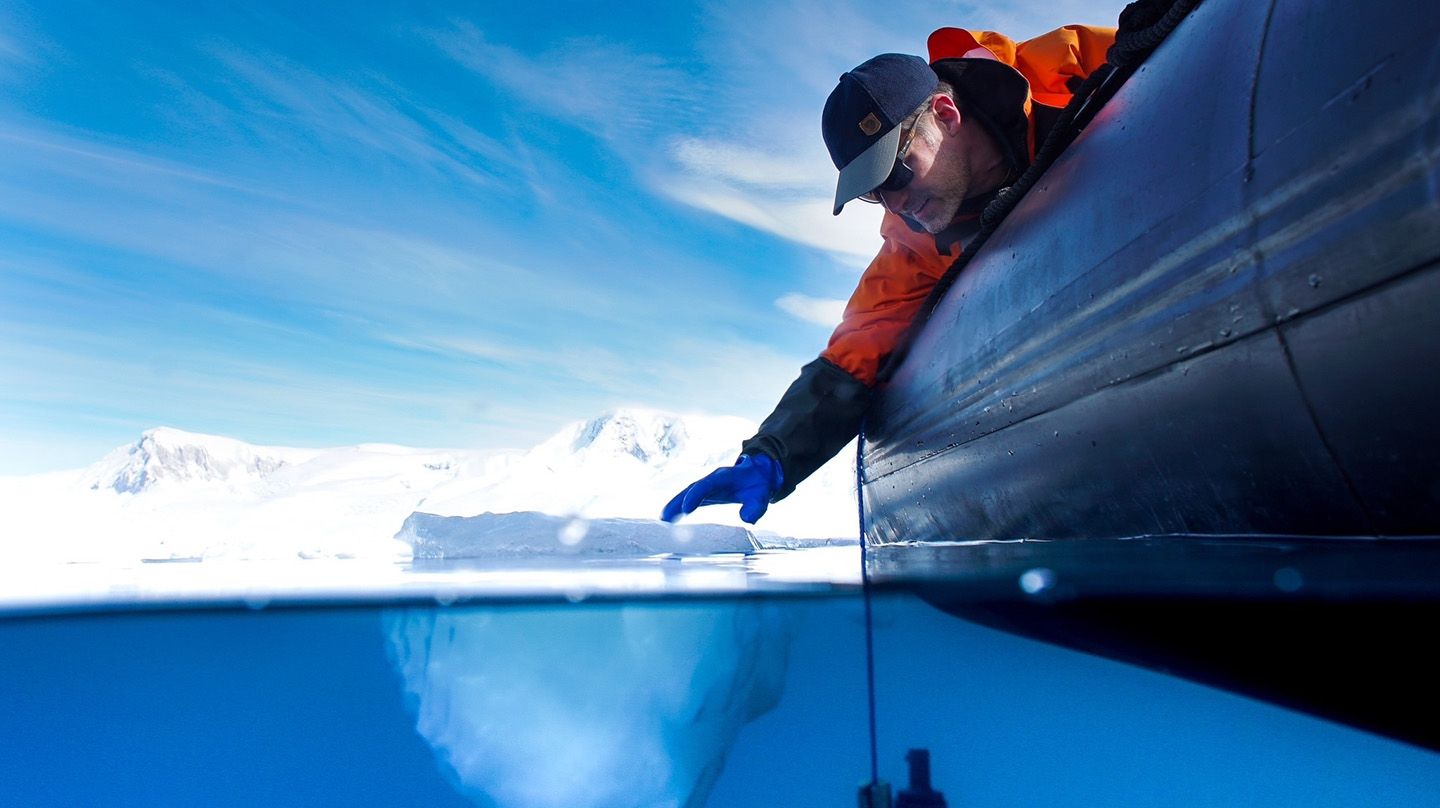 Peter Thielen touches a floating piece of ice