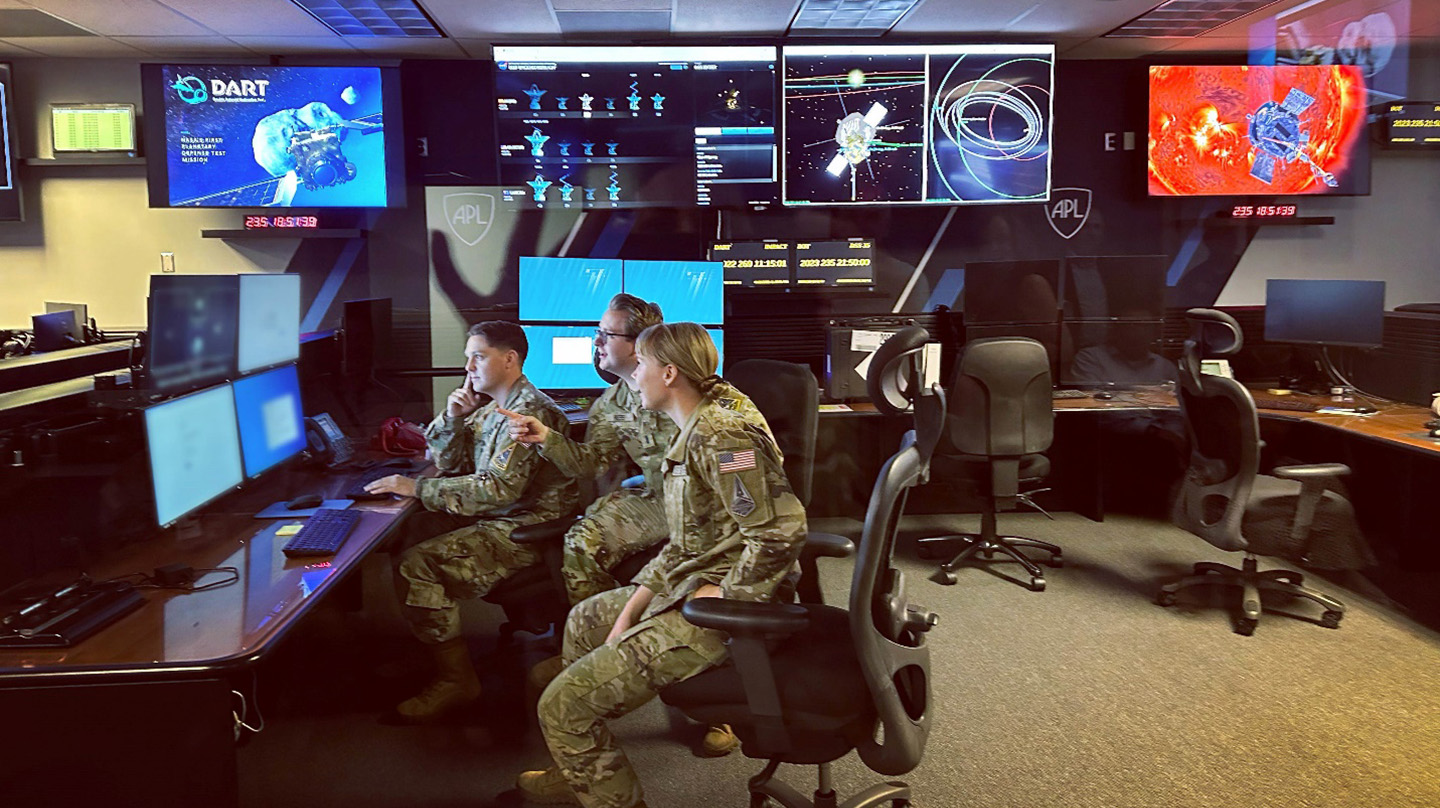 Capt. Brandon Johnson, Lt. Matt Ress, and Lt. Jennifer Leo inside Johns Hopkins APL's Multi-Mission Operations Center