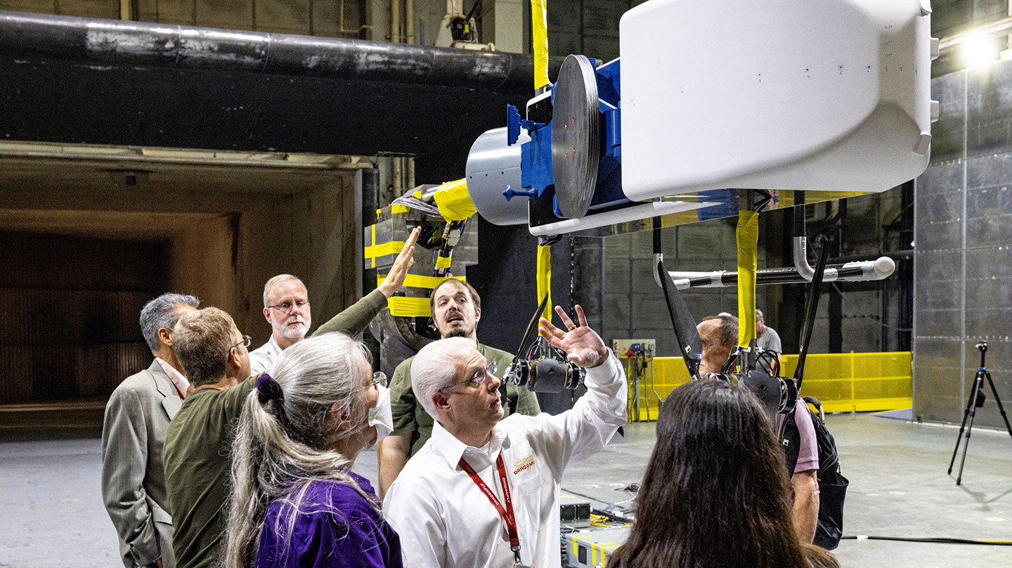 Dragonfly team members review the half-scale lander model after it underwent wind tunnel testing