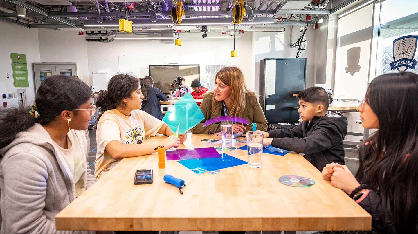 Nelli Mosavi-Hoyer (center) discusses the EZIE-Mag kits with ASPIRE students.