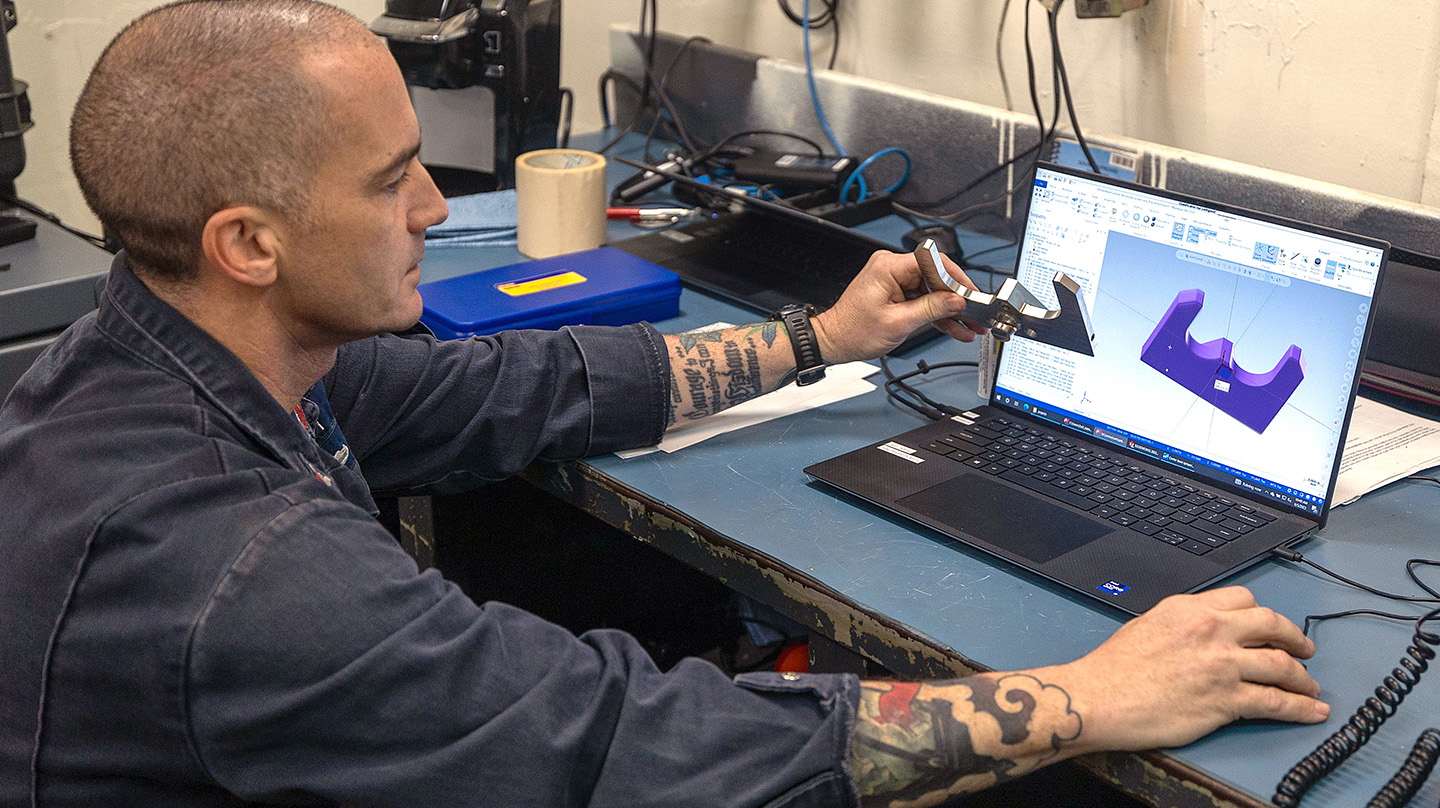 Machinery Repairman 1st Class Cory Hover demonstrates the software used to design the sprayer plate