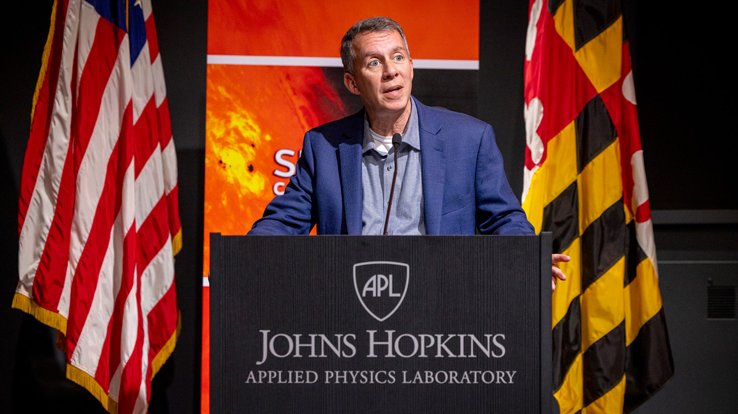 Bobby Braun stands behind a lectern to present during the SEASONS 2023 Conference hosted on the Johns Hopkins APL campus.