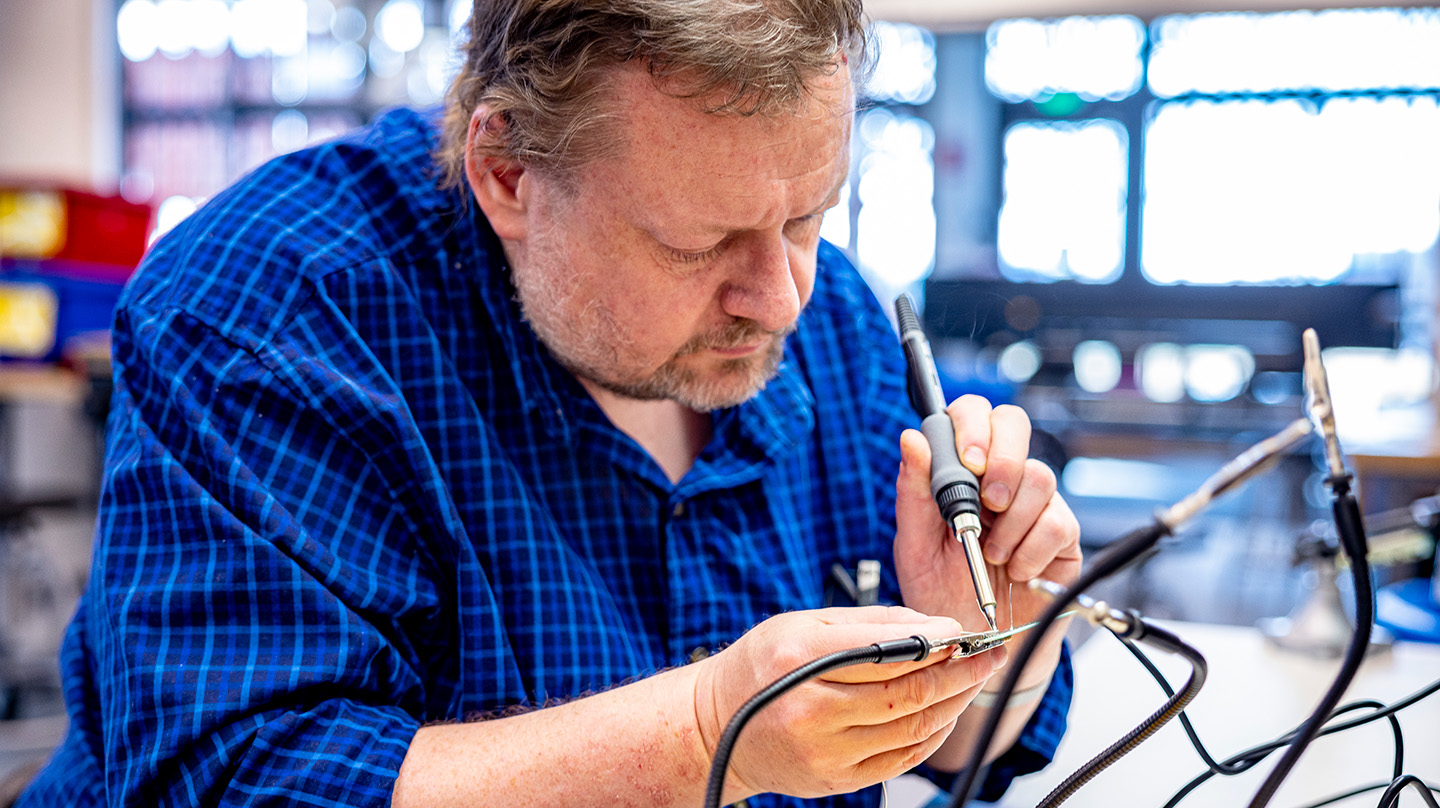 Rob Barnes solders a printed circuit board prototype for the EZIE-Mag kit.