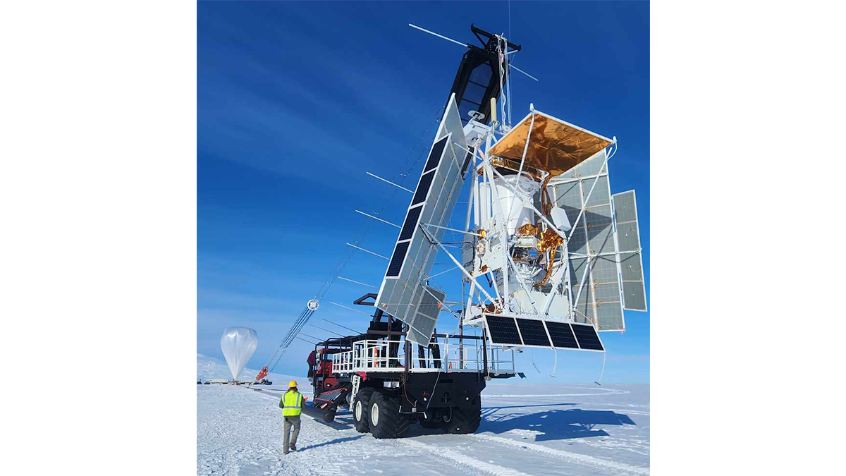 As the zero-pressure balloon that will carry GUSTO around the South Pole inflates, the GUSTO science payload hangs from a crane before its release to the sky. (Credit: NASA/Columbia Scientific Balloon Facility/Haydon Boyd)