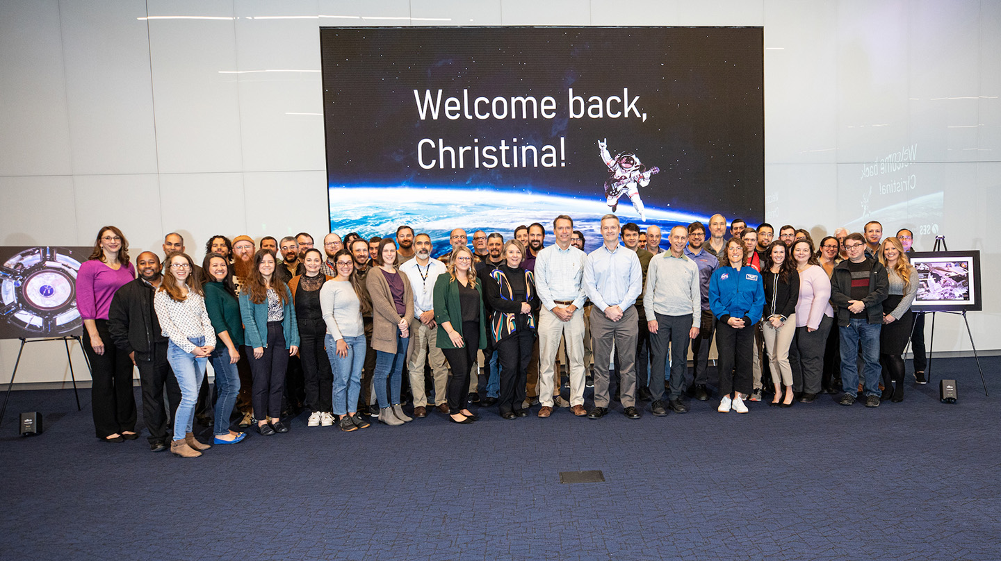 Astronaut and former APL electrical engineer Christina Koch poses with APL staff members